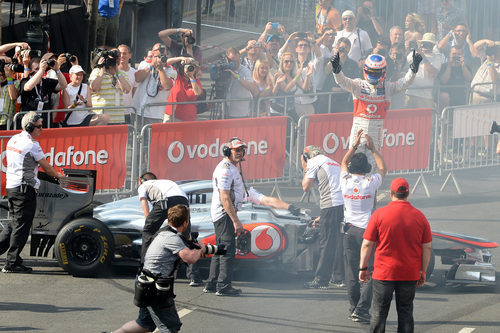 Jenson Button de pie encima de su McLaren