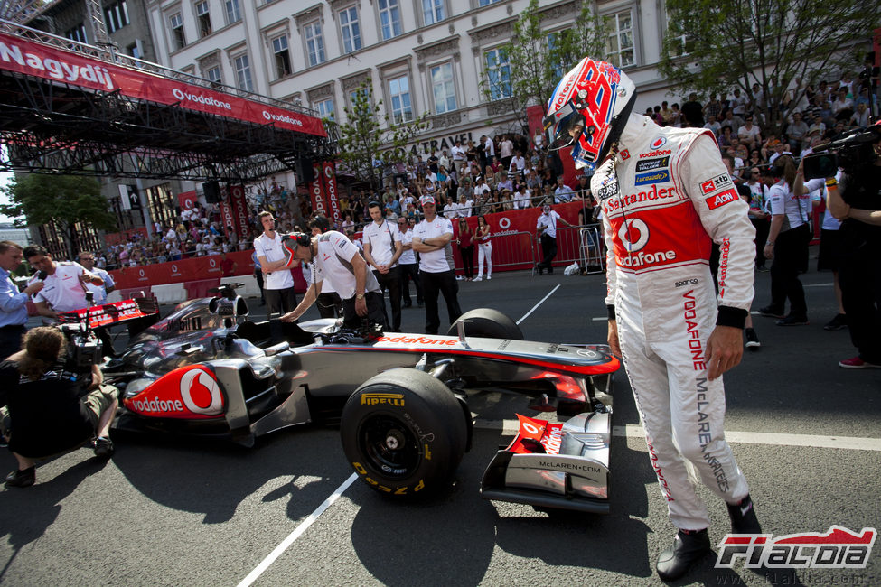 Jenson Button mira a su McLaren tras la exhibición en Budapest