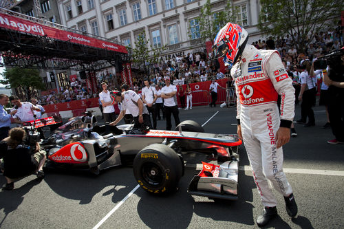 Jenson Button mira a su McLaren tras la exhibición en Budapest