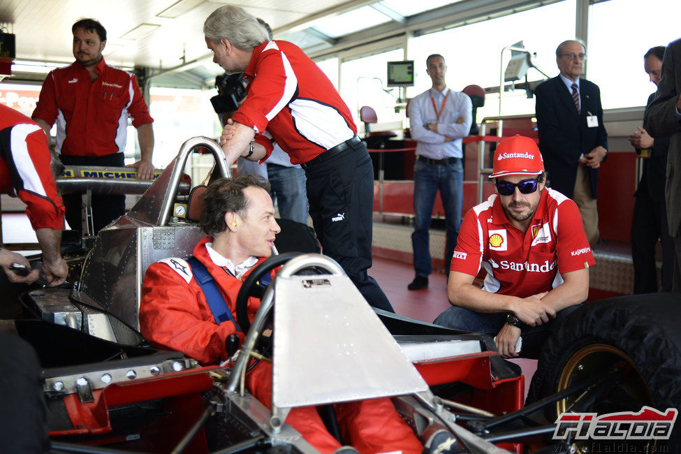 Jacques Villeneuve sentado en el Ferrari 312 T4 junto a Fernando Alonso