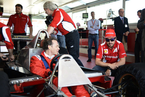 Jacques Villeneuve sentado en el Ferrari 312 T4 junto a Fernando Alonso