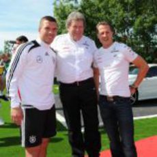 Norbert Haug y Michael Schumacher con Lukas Podolski