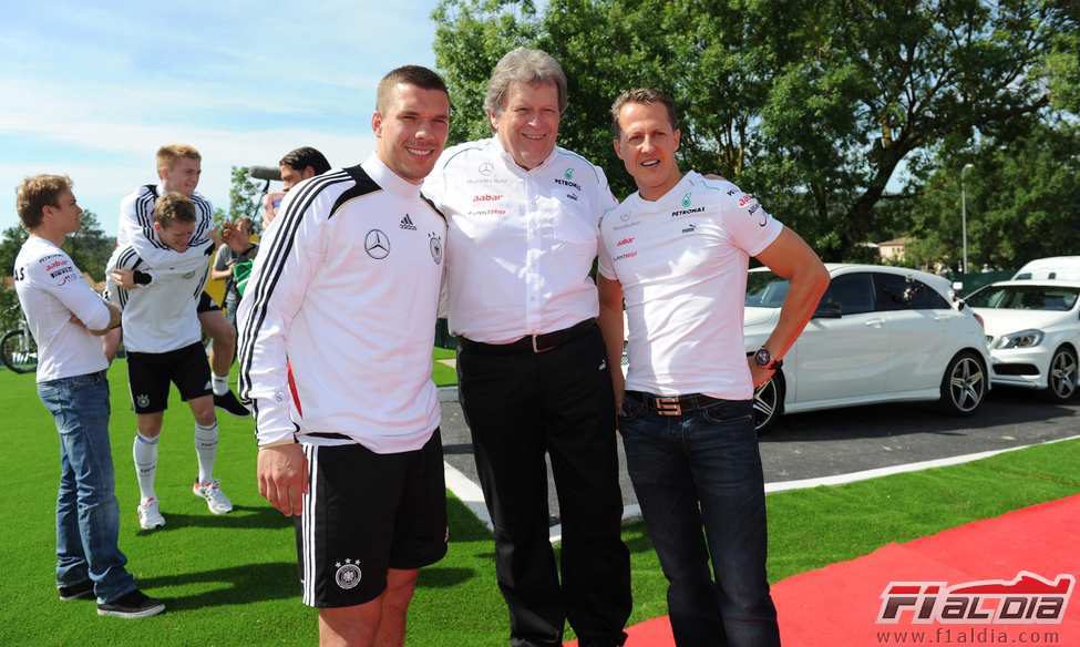 Norbert Haug y Michael Schumacher con Lukas Podolski