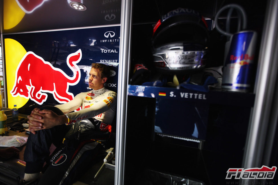 Sebastian Vettel espera sentado en el garaje de Red Bull