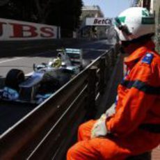 Un comisario de pista observa pasar a Nico Rosberg