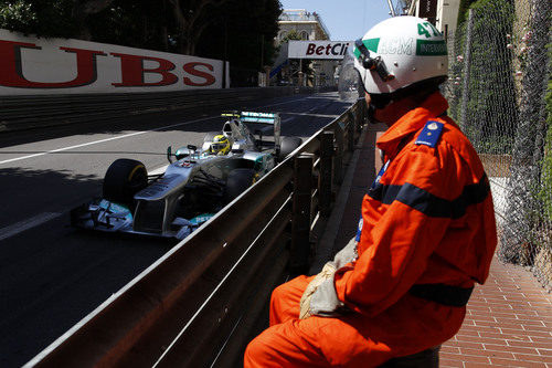 Un comisario de pista observa pasar a Nico Rosberg