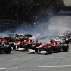 Fernando Alonso adelanta por fuera en la primera curva