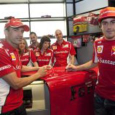 Marc Gené y Fernando Alonso firman sobre el mostrador de la Ferrari Store