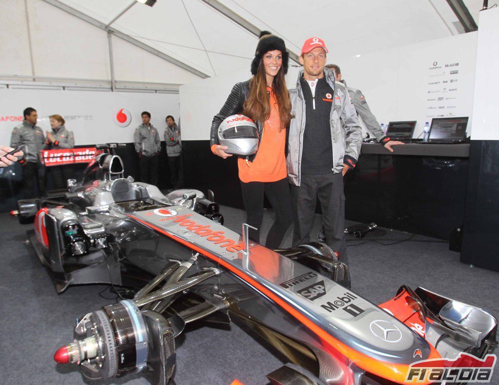 Jenson Button posa junto a su coche y una modelo local