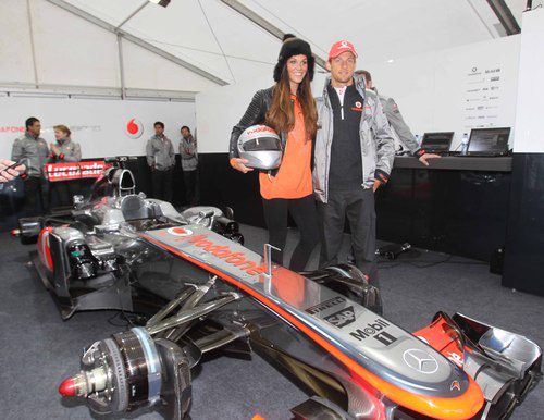 Jenson Button posa junto a su coche y una modelo local