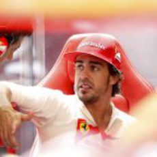 Fernando Alonso discute con sus ingenieros en el box de Valencia