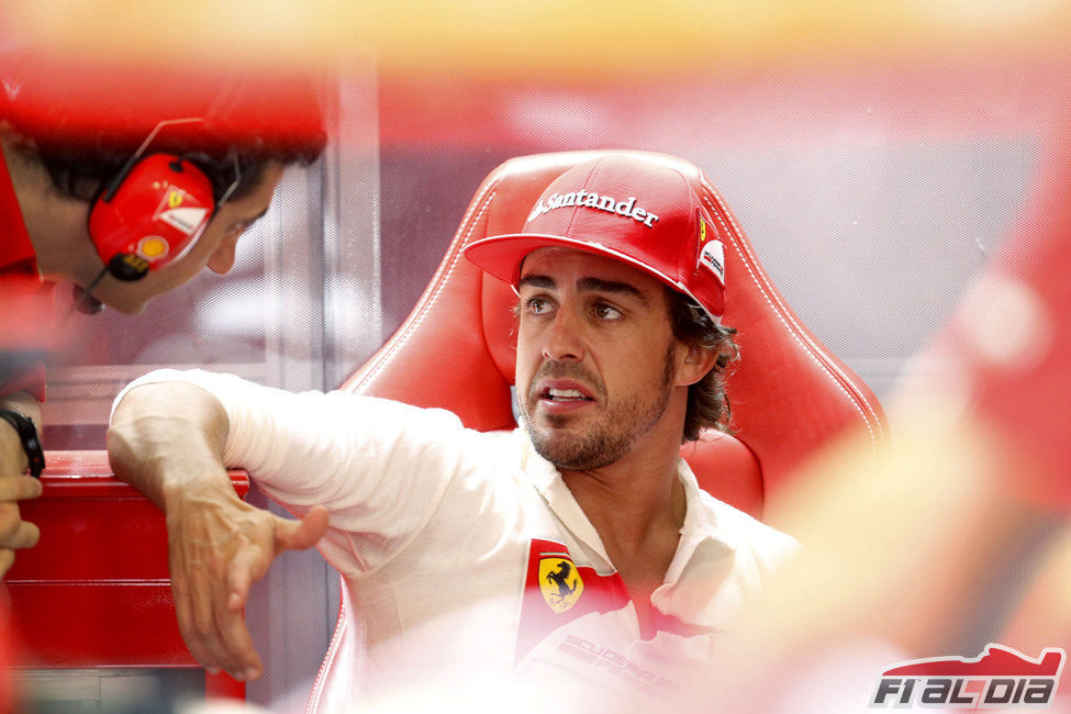 Fernando Alonso discute con sus ingenieros en el box de Valencia