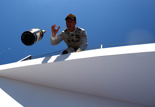 Michael Schumacher tira la botella de champán desde el podio de Valencia 2012