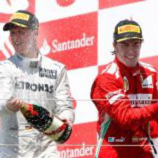 Schumacher y Alonso disfrutan con el champán en el podio de Valencia 2012