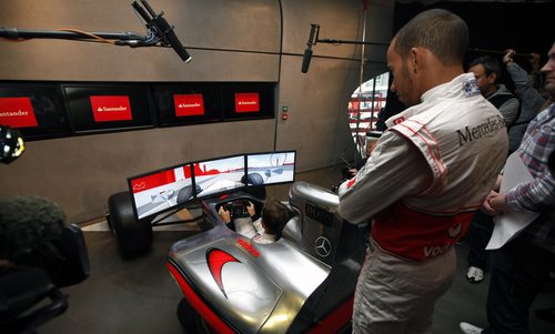 Lewis Hamilton observa a Jenson Button completar una vuelta en Londres
