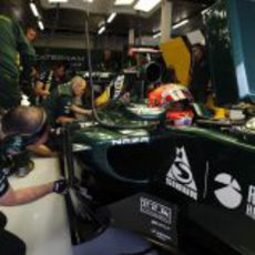 Los mecánicos observan el monoplaza de Heikki Kovalainen