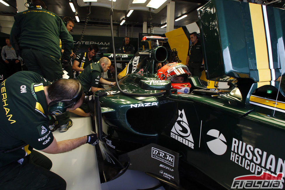 Los mecánicos observan el monoplaza de Heikki Kovalainen