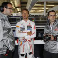 Jenson Button habla con algunos mecánicos del equipo