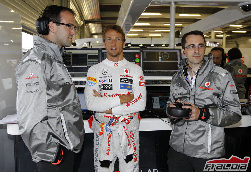 Jenson Button habla con algunos mecánicos del equipo