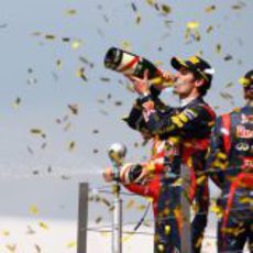 Mark Webber bebe champán en el podio de Silverstone