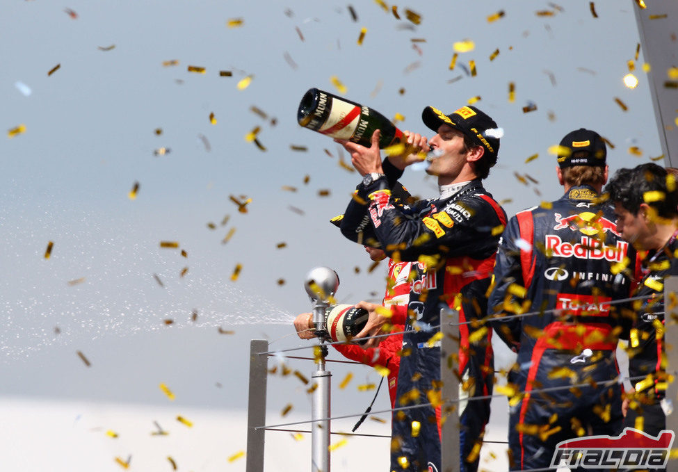 Mark Webber bebe champán en el podio de Silverstone