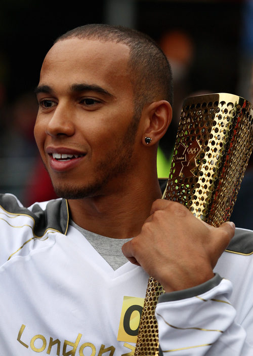 Lewis Hamilton abraza la antorcha olímpica de Londres