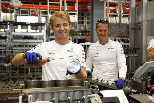 Rosberg lubrica el motor ante la mirada de Schumacher