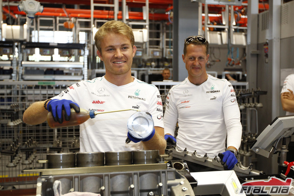 Rosberg lubrica el motor ante la mirada de Schumacher