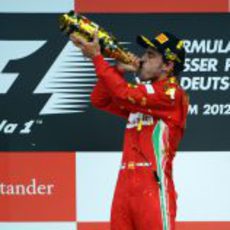 Fernando Alonso bebe champán en el podio de Alemania 2012