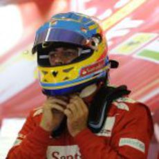 Fernando Alonso se ajusta el casco en el box de Ferrari