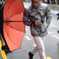 Lewis Hamilton pasea por el 'pit lane' de Spa con un paraguas