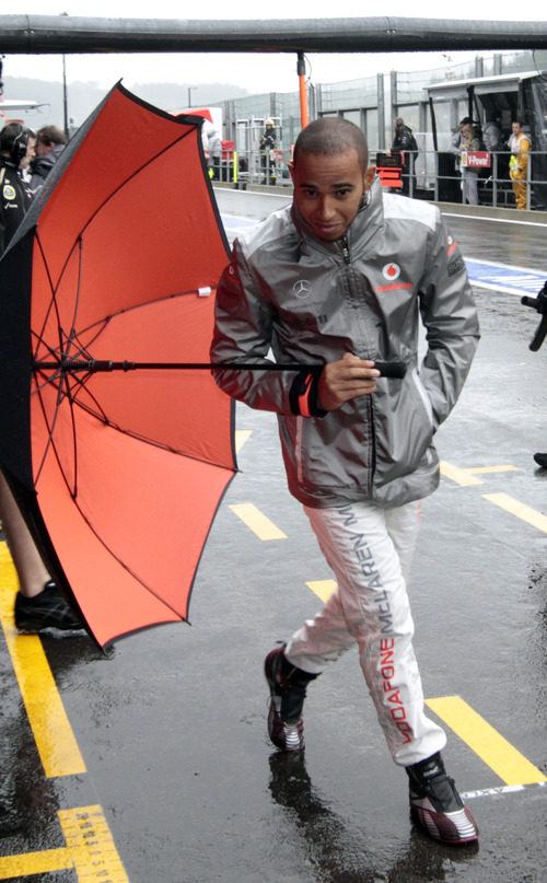 Lewis Hamilton pasea por el 'pit lane' de Spa con un paraguas