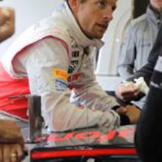 Jenson Button espera en el box de McLaren a que pare la lluvia