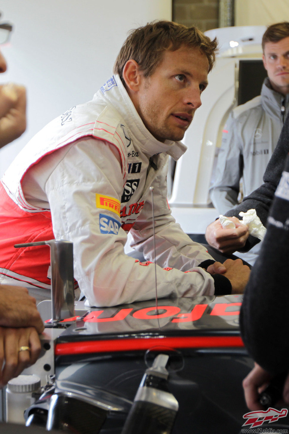 Jenson Button espera en el box de McLaren a que pare la lluvia