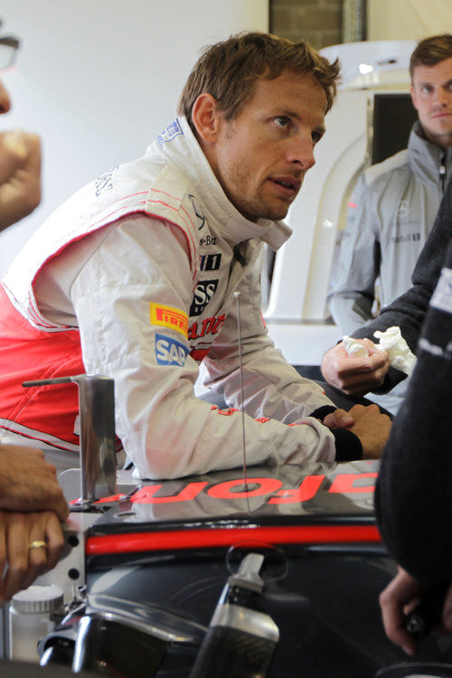 Jenson Button espera en el box de McLaren a que pare la lluvia