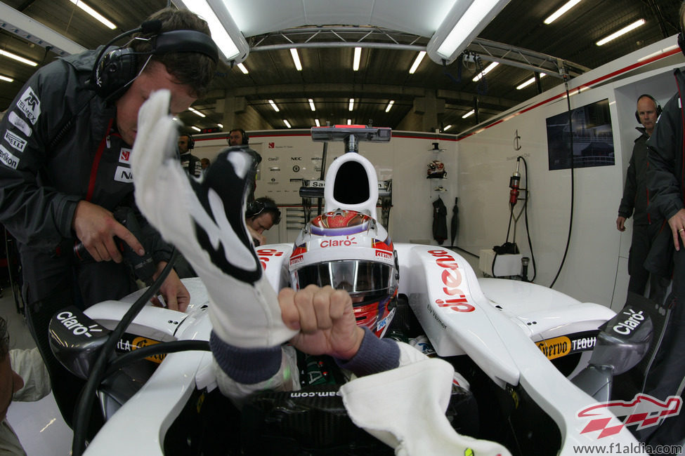 Kamui Kobayashi se pone los guantes en el interior de su Sauber