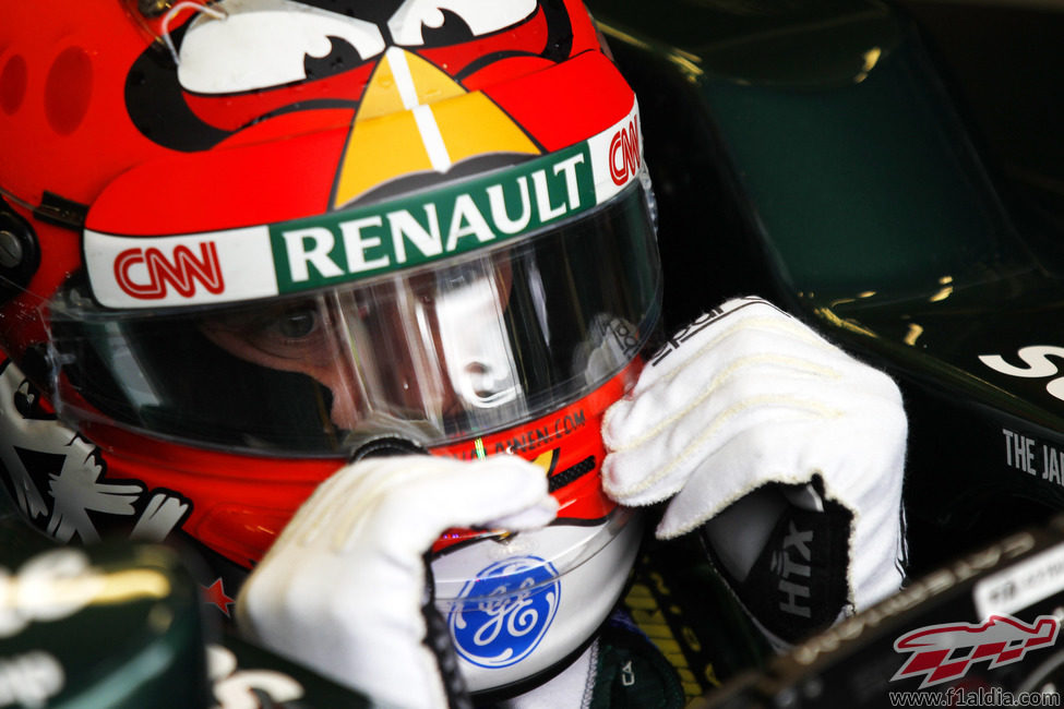 Heikki Kovalainen se ajusta la visera del casco antes de salir a pista