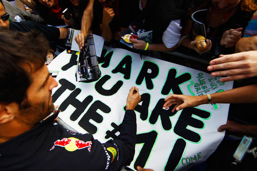 Mark Webber firma una pancarta a su llegada a Spa