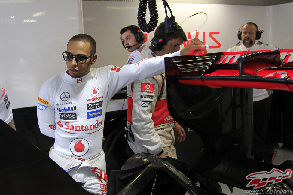 Lewis Hamilton se apoya en el alerón trasero de su McLaren