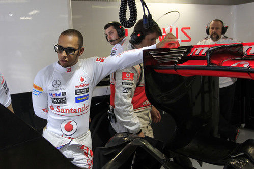 Lewis Hamilton se apoya en el alerón trasero de su McLaren