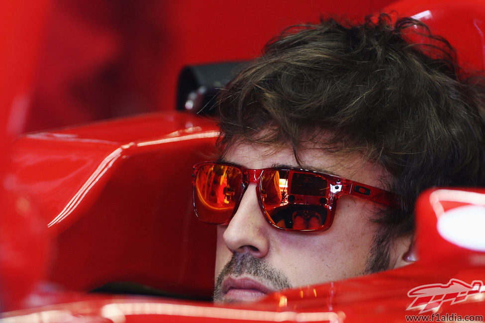 Fernando Alonso sentado en el F2012 con sus gafas de sol puestas