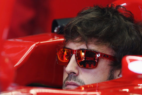 Fernando Alonso sentado en el F2012 con sus gafas de sol puestas