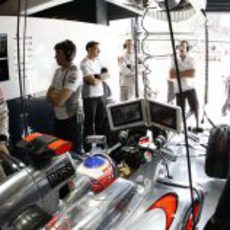 Jenson Button, atento a las pantallas desde el box de McLaren