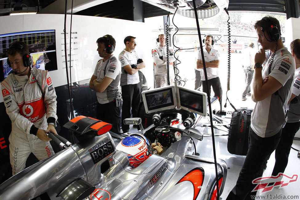 Jenson Button, atento a las pantallas desde el box de McLaren