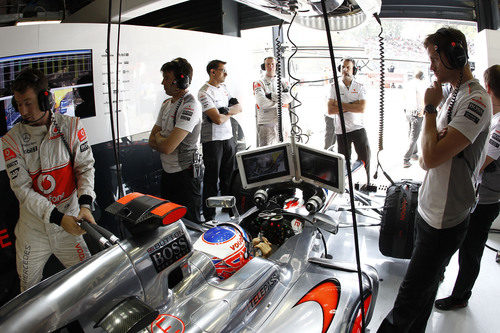 Jenson Button, atento a las pantallas desde el box de McLaren