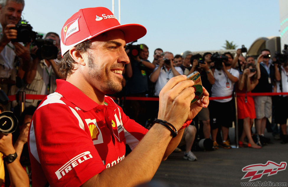 Fernando Alonso sacando fotos con su iPhone en Monza