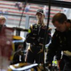 Romain Grosjean observa a sus mecánicos manipulando el Lotus E20