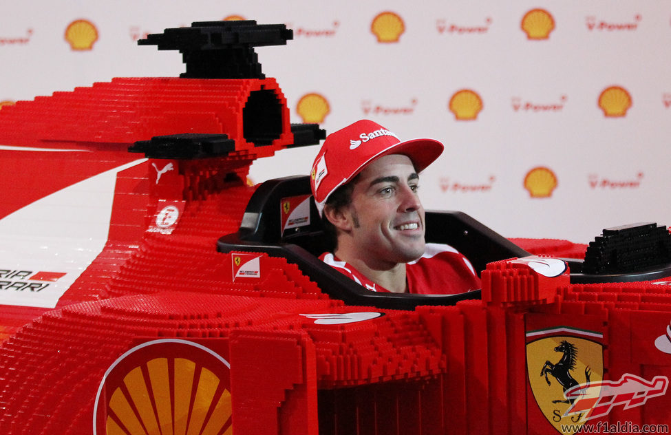 Fernando Alonso feliz sentado en el Ferrari de LEGO