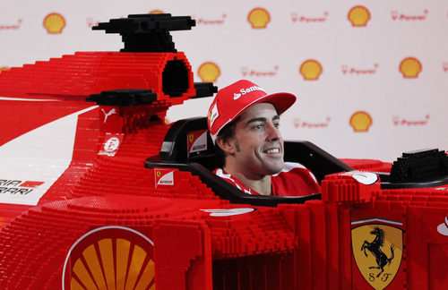 Fernando Alonso feliz sentado en el Ferrari de LEGO