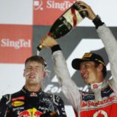 Jenson Button baña en champán a Sebastian Vettel en el podio